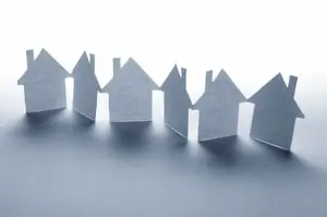 close up of houses cut out of paper on white background